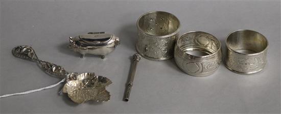 A continental silver pig box, a white metal caddy spoon, a propelling pencil & three silver napkin rings.